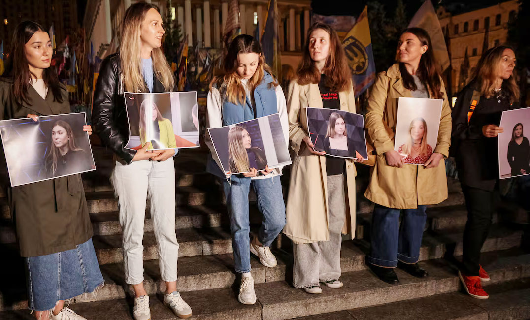 People hold portraits of Ukrainian journalist Victoria Roshchyna, who died in Russian captivity, as they take part in commemoration rally for her, amid Russia's attack on Ukraine, in Kyiv, Ukraine
